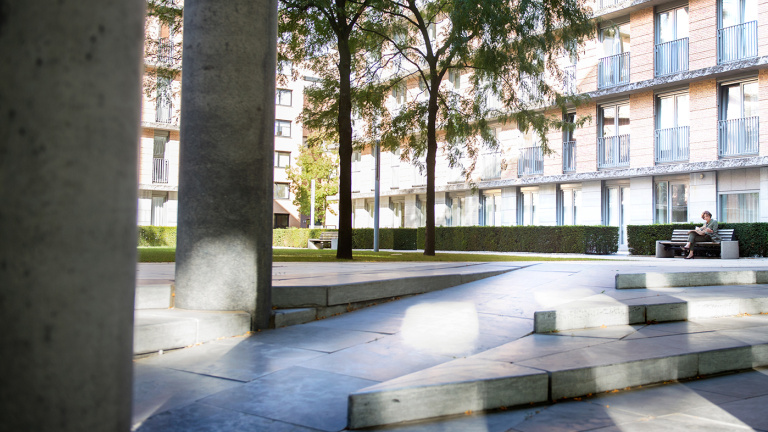Student stands in front of the smart board in the classroom and gives presentation to his fellow students at the hotel school maastricht.