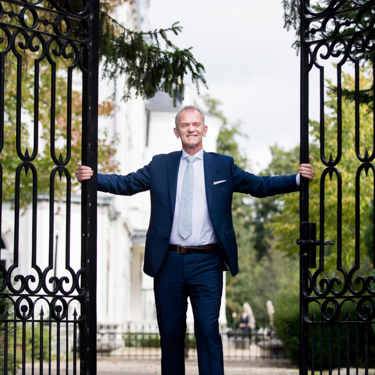 Ad Smits staat voor de poort van de Hotelschool Maastricht